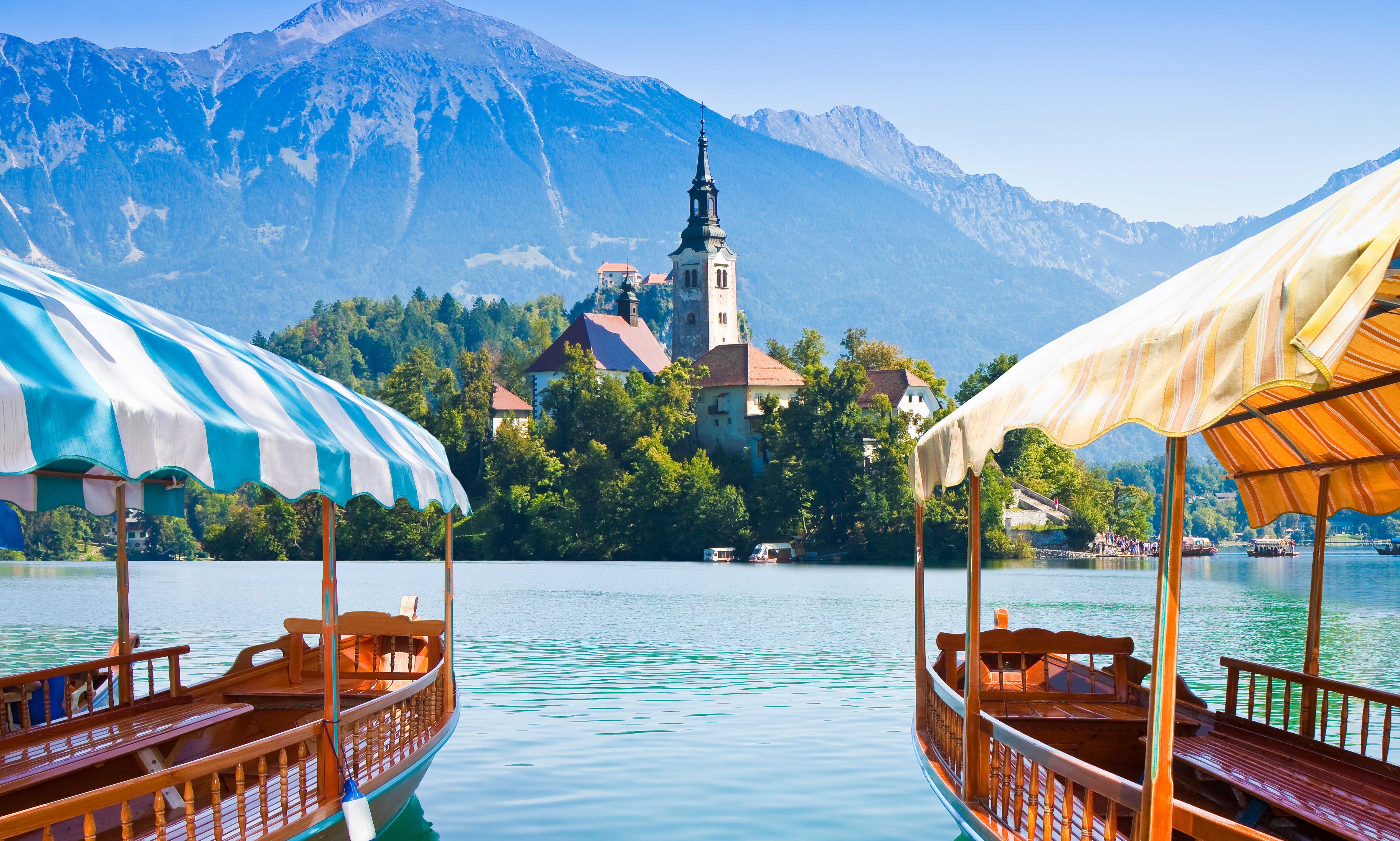 Two boats on the lake facing Bled Island and Bled Castle.